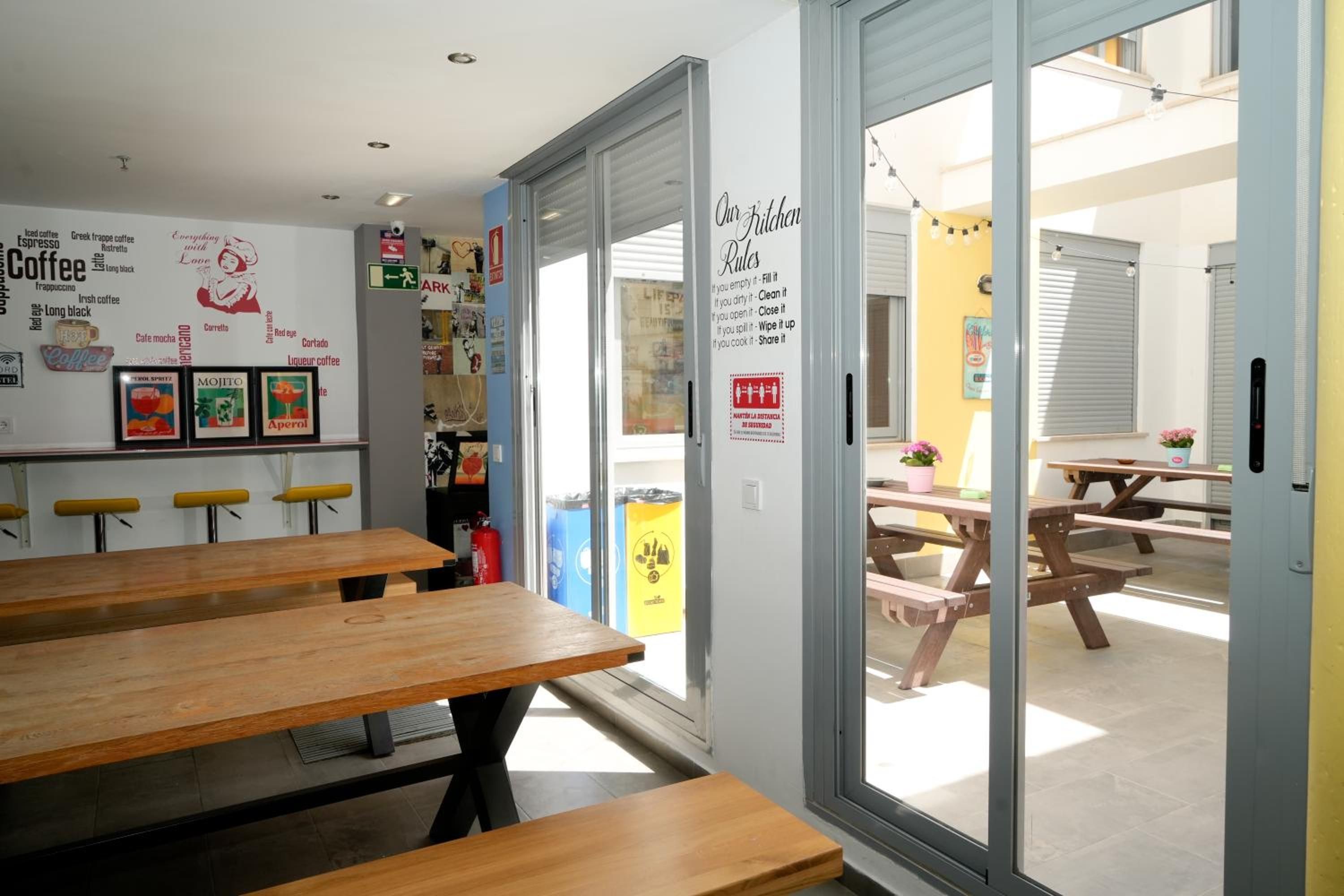 Un intérieur agrémenté de tables en bois et d’un mur décoré de mots et d’images liés au café.