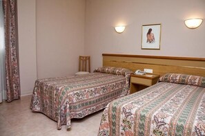 A hotel room with two single beds, a wooden nightstand, a chair, and a framed picture on the wall. - Hotel La Piqueta (Benassal)