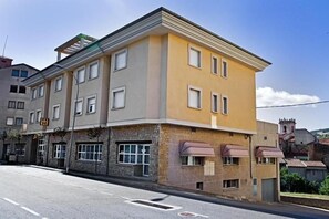 A multi-story building with a flat facade, several windows, and a ground-level entrance.