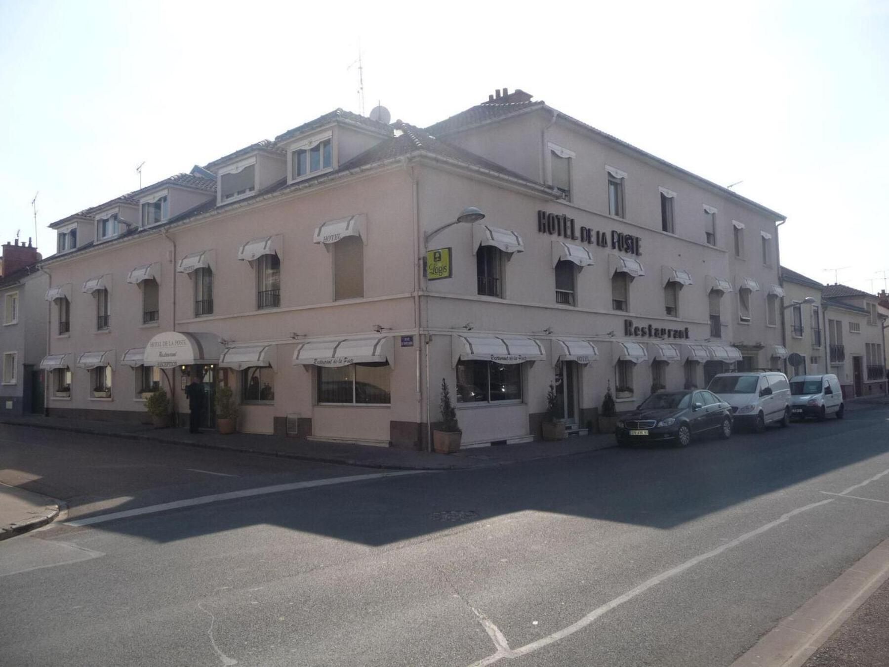 A building with multiple storefronts, including a hotel and a restaurant.