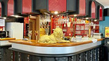 Eine Bar mit einem Löwenstatuen-Zentrum, einem Weinkühlschrank und einer gefliesten Rückwand.