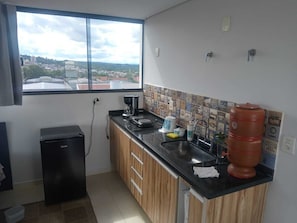 A compact kitchen with a window, a coffee maker, a sink, and a large red container. - Studio 42 in Mogi Guaçu (Mogi Guaçu)