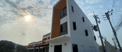 Un bâtiment moderne doté d’un toit plat, de nombreuses fenêtres et surplombant un ciel dégagé.