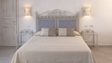 Une chambre à coucher avec un lit, deux tables de chevet, une porte et un papier peint à motifs.