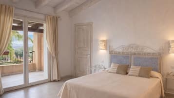 Quarto com cama, cortinas, uma porta e vista através de uma porta de vidro.