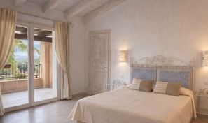 A bedroom with a bed, curtains, a door, and a view through a glass door.