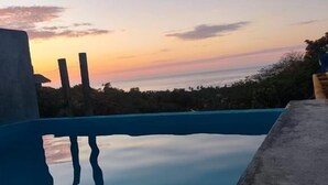 Una piscina con una vista despejada del atardecer al fondo.