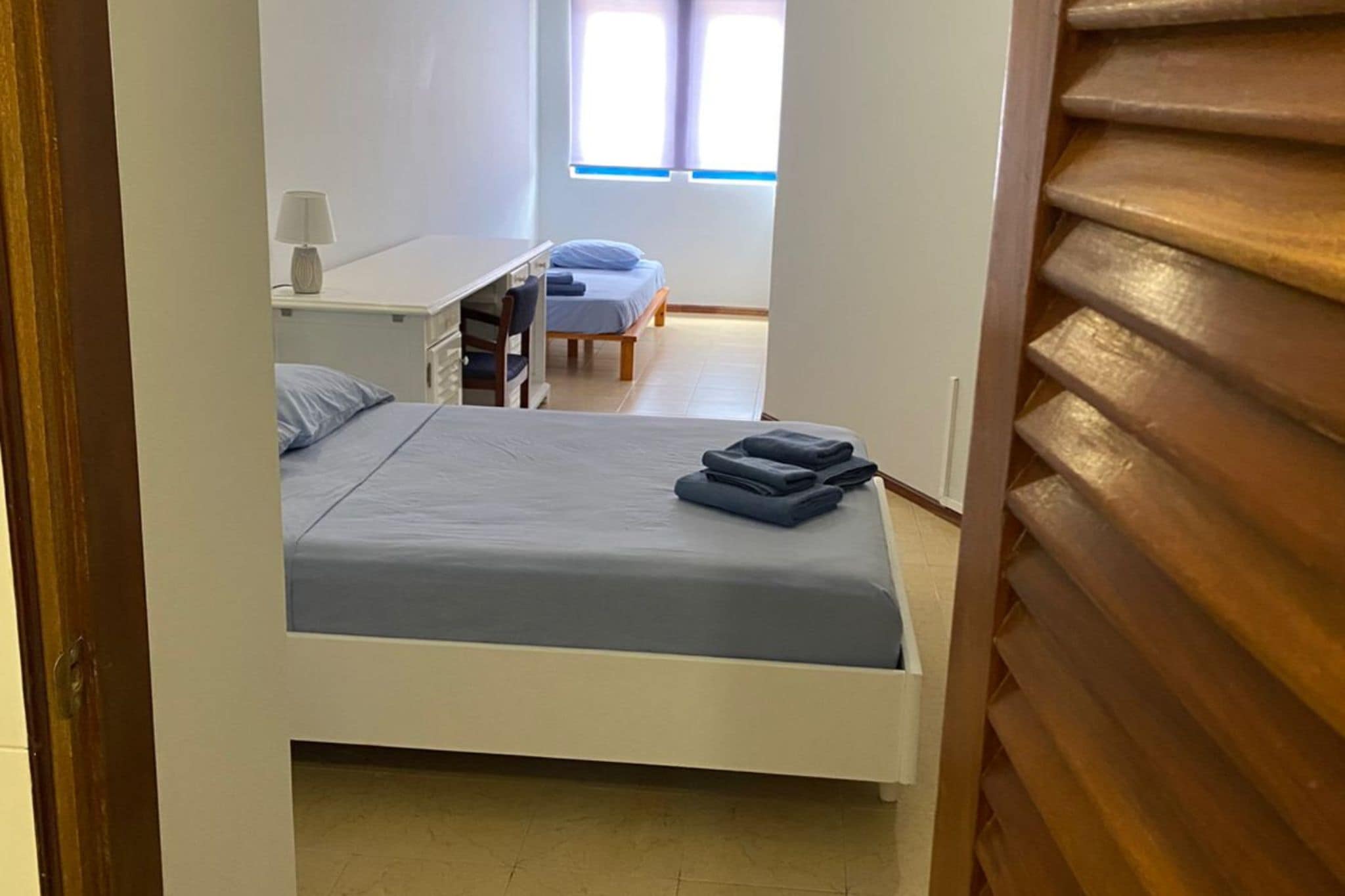 Un dormitorio con cama, escritorio y silla.