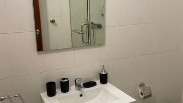 A bathroom with a white sink, a mirror, and a towel rack.