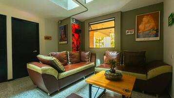 A living room with a sofa, a coffee table, and a window with a view.