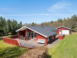 A red two-story house with a deck, a garage, and a covered porch. - "Ulfsten" - 2km from the sea by Interhome (Saltum)