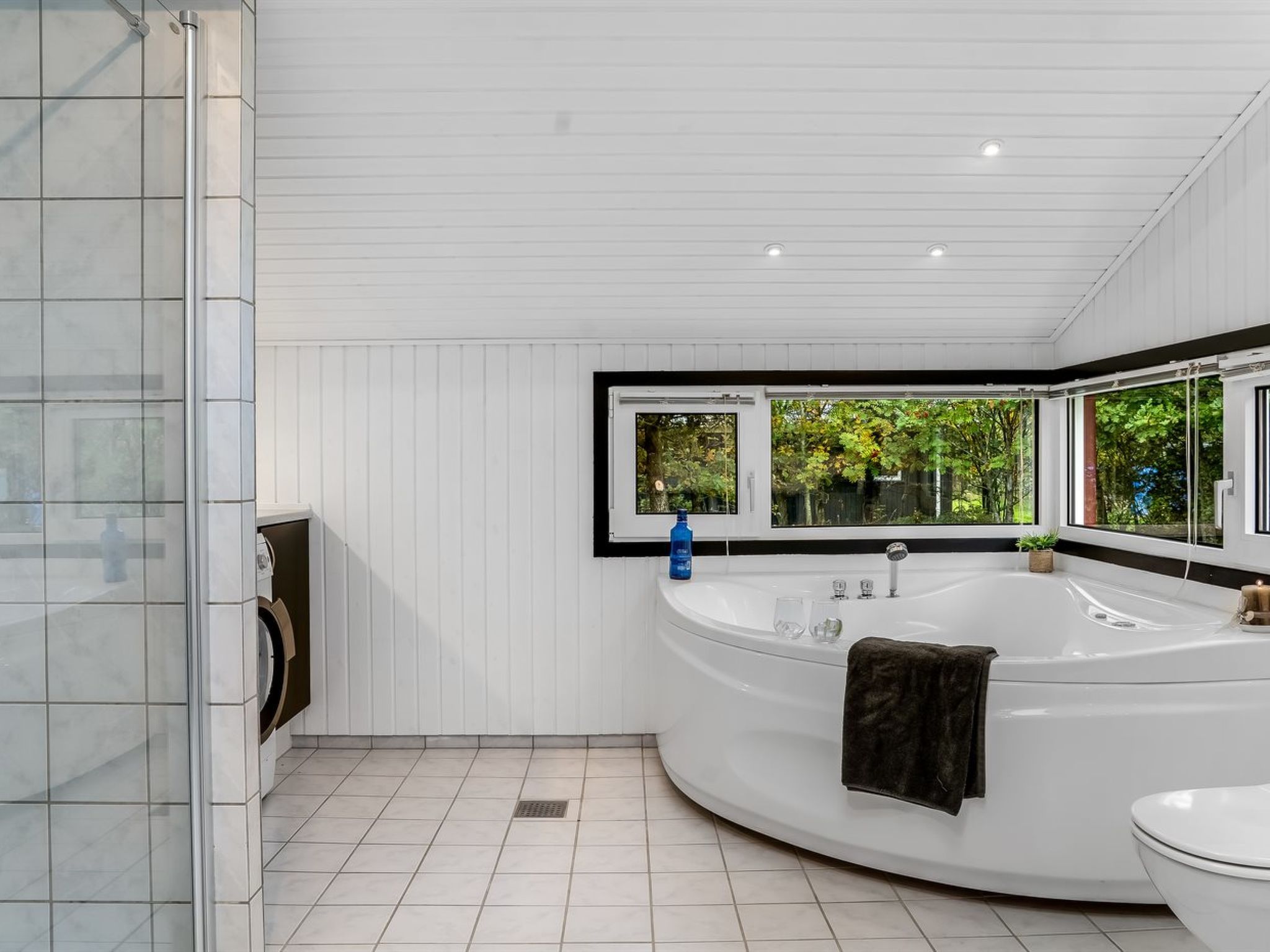 A modern bathroom with a freestanding bathtub, a toilet, and a shower area.