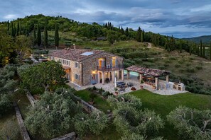 A stone house with a patio, outdoor seating, and a pool.
