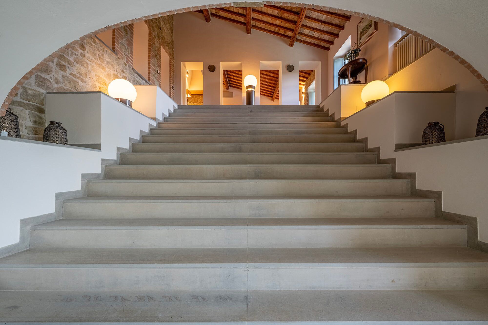 A staircase with a stone archway leading to a second floor.