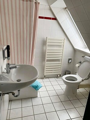 Ein Badezimmer mit Waschbecken, Toilette und Handtuchhalter.