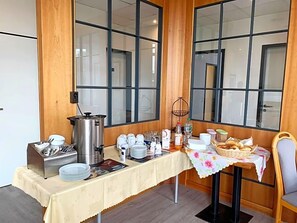 Ein Frühstücksbuffet mit Kaffeekannen und einem Korbwasserkorb.