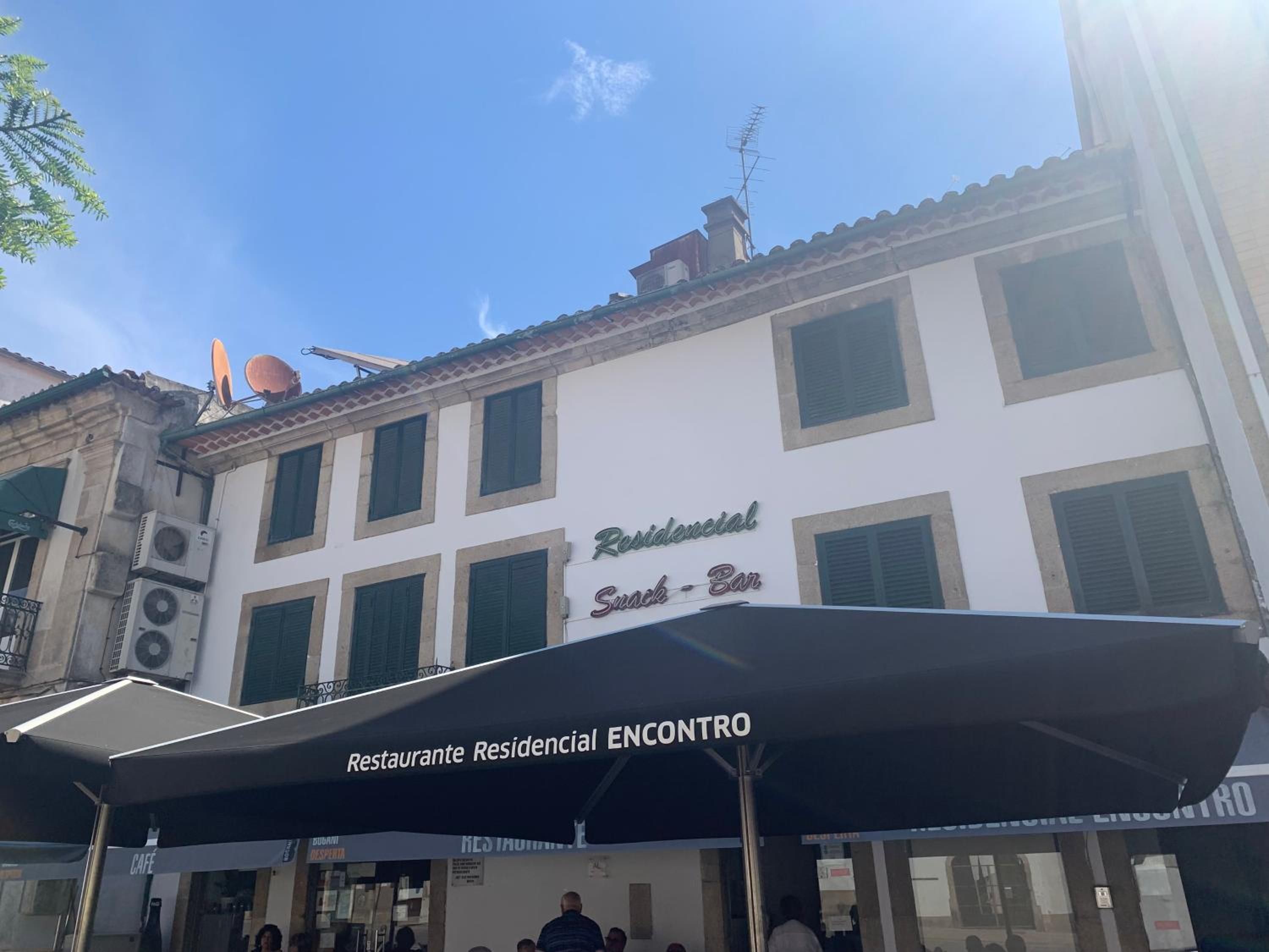 Un bâtiment avec une enseigne indiquant « Restaurante Residencial ENCONTRO » et un auvent noir.