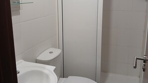 A bathroom with a toilet, sink, and shower. - Residencial Encontro (Vila Real)