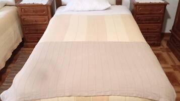 A standard hotel room with a single bed, two wooden nightstands, and a wooden headboard.
