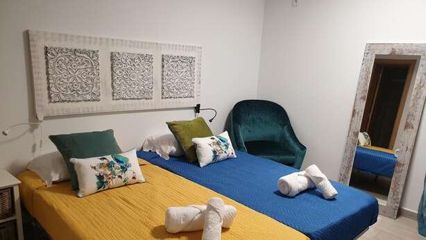 A room with a bed, a chair, and a wall-mounted artwork. - Lisbon Hostel Terminal 4 (Lisbon)