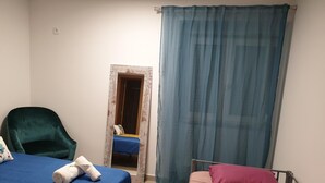 A bedroom with two beds, a chair, and a door leading to another room. - Lisbon Hostel Terminal 4 (Lisbon)