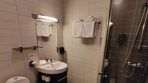 Un baño moderno con inodoro, lavabo y ducha.