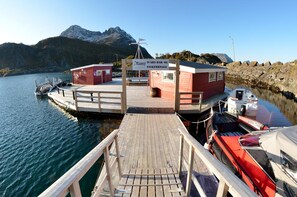A wooden dock leading to a small building with a sign reading 'Hammarskjold Bar- og Fiskebrygge.' - Hamn I Senja (Senja)