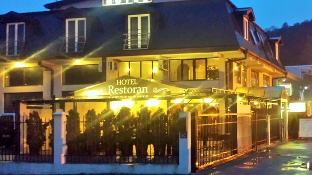 A hotel with a sign reading 'HOTEL Restoran' and a covered outdoor seating area. - Hotel Topcider (Belgrade)