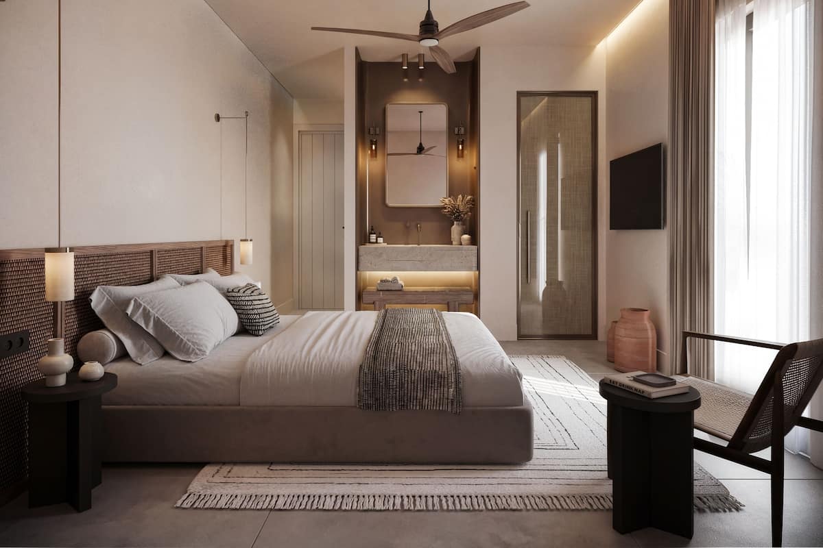 Ein modernes Schlafzimmer mit Bett, Nachttischen, Deckenventilator, Fernseher und einem Badezimmer mit Dusche.