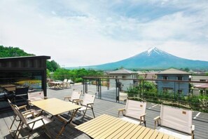 Una terraza en la azotea con mobiliario exterior y vistas a la montaña.
