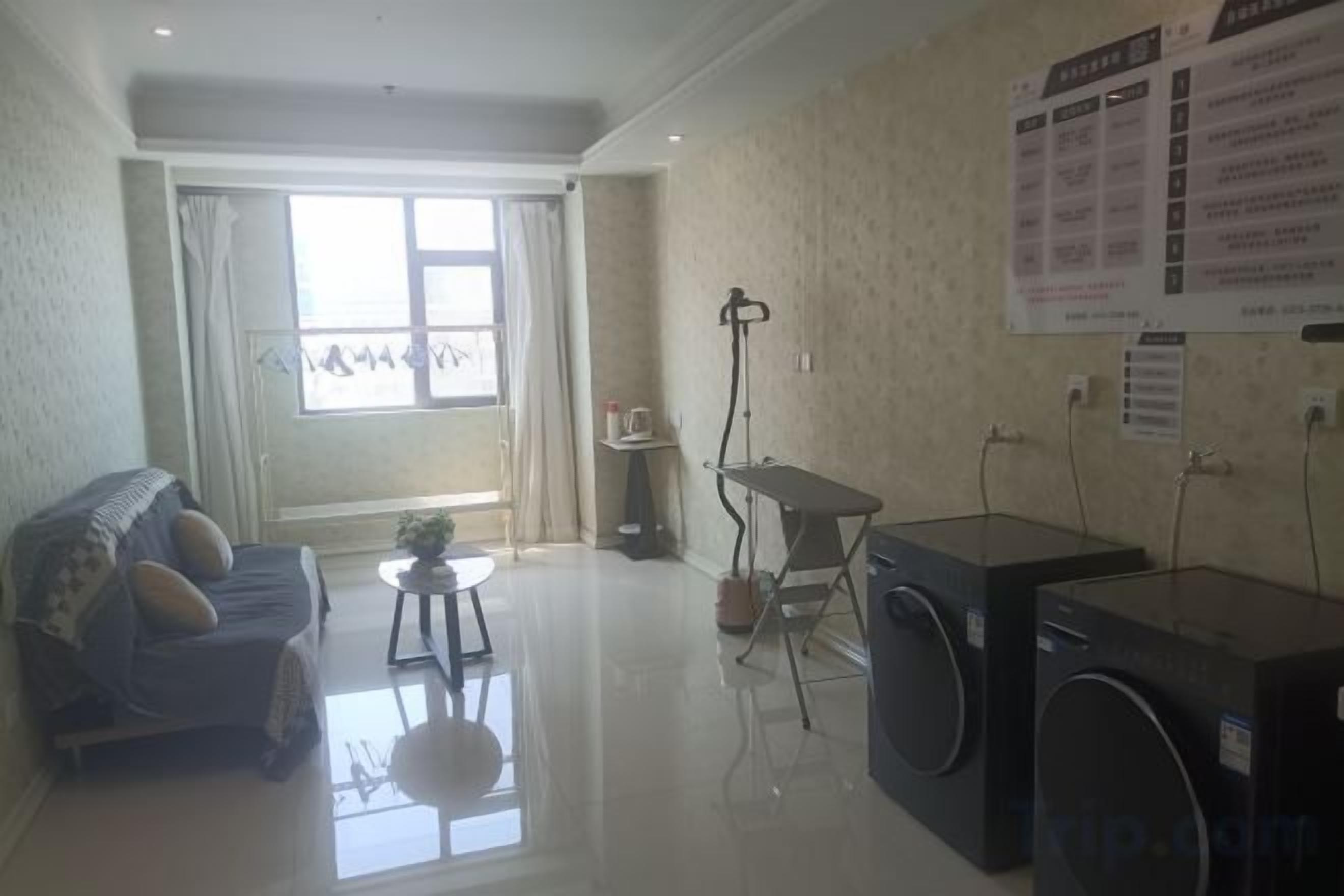 A living room with a sofa, a small table, and a washing machine.