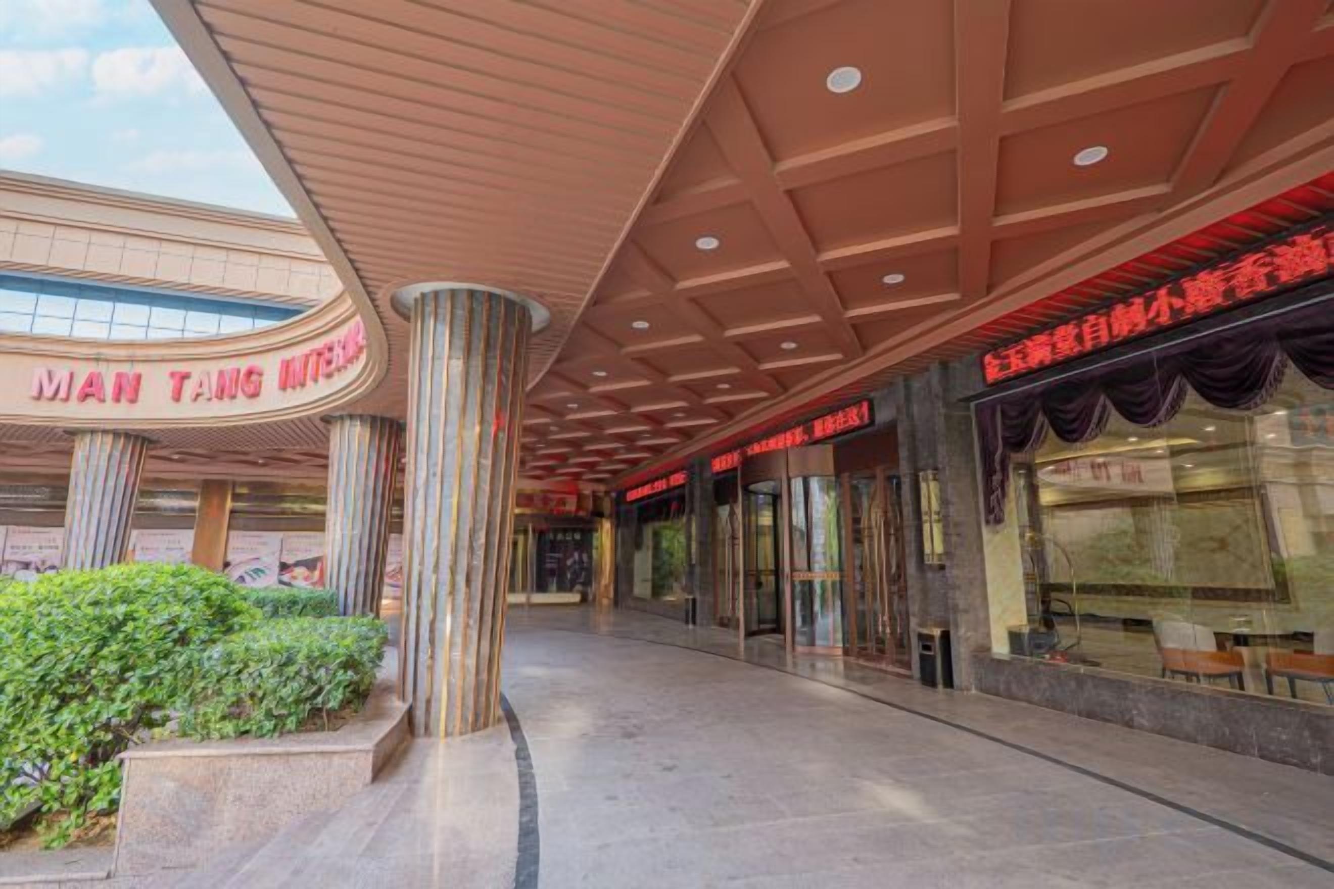 A building entrance with a curved facade, large columns, and a covered walkway.