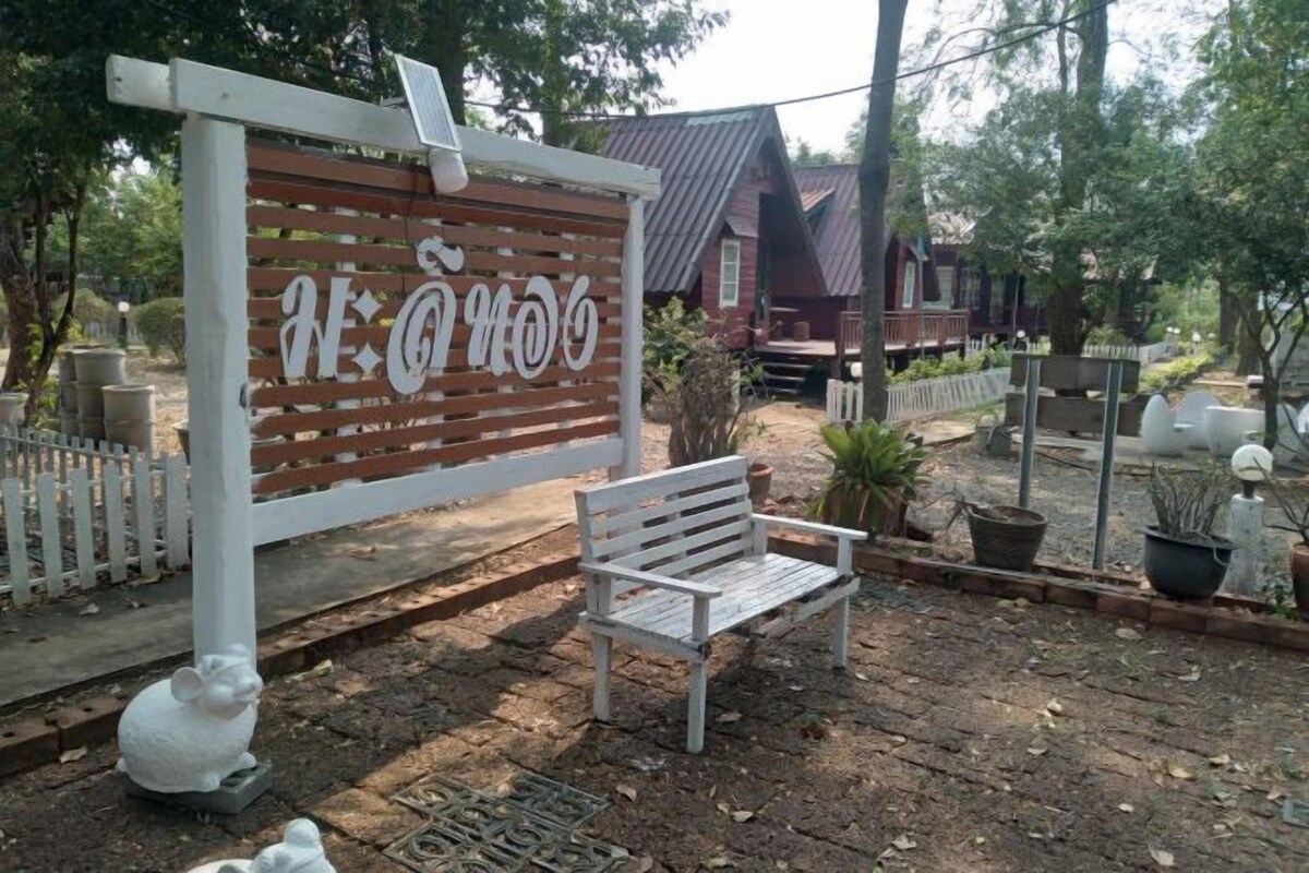 A wooden bench, a white fence, and a sign with text.