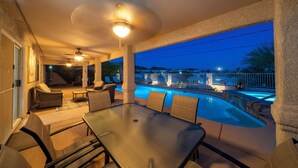 A covered outdoor area with a pool, seating, and ceiling fans. - Desert Horizon Retreat - Pool, Spa & Desert Views (Lake Havasu City)