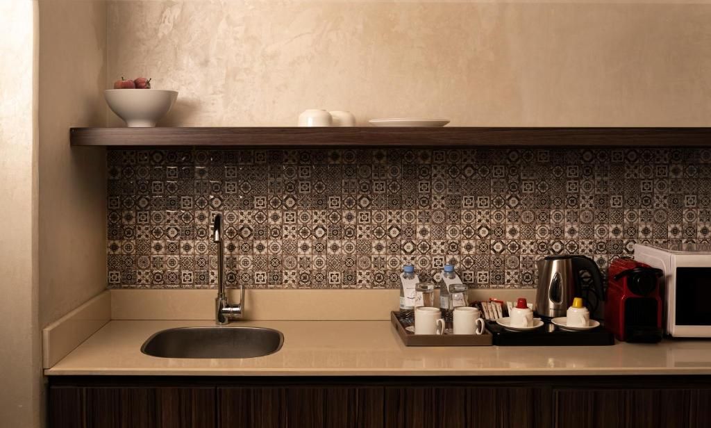 Una cocina con un fregadero, una cafetera y un microondas sobre la encimera.