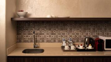 Una cocina con un fregadero, una cafetera y un microondas sobre la encimera.