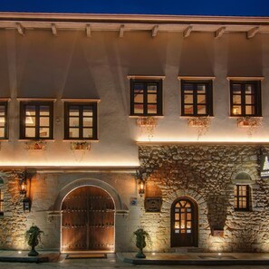 A building with a stone facade, multiple windows with dark frames, and a large wooden double door. - Kamares Boutique Hotel & Spa Ioannina (Ioannina)