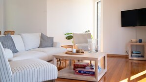 Een moderne woonkamer met een bank, salontafel en televisie.