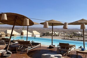 A poolside area with lounge chairs and umbrellas, overlooking a desert landscape. - Mia Agafay Resort (Agafay)