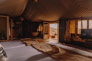 A room with a large bed, a television, and a view of the desert. - Mia Agafay Resort (Agafay)