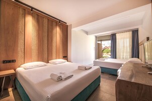 Habitación de hotel con dos camas, un ventanal grande y vistas al exterior.