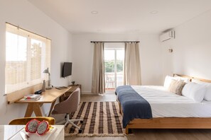 A hotel room with a bed, desk, chair, and a view of the outdoors. - Outsite Vilamoura Adults Only (Loulé)
