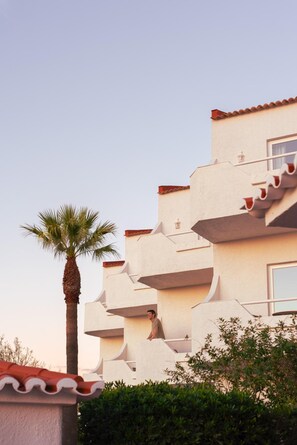 A multi-story building with a unique architectural design featuring protruding balconies and a red-tiled roof. - Outsite Vilamoura Adults Only (Loulé)