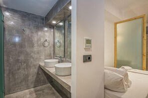 Un baño con dos lavamanos redondos, un espejo y una zona de ducha.