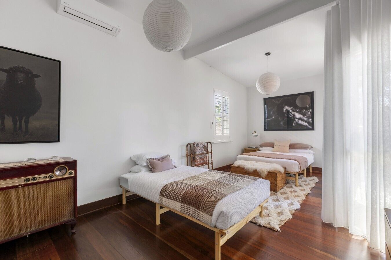 A bedroom with a bed, bedside table, lamp, and a large framed picture on the wall.