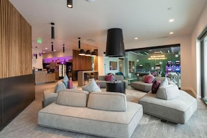 A modern lobby with sofas, a reception desk, and a bar area. - Yotelpad Park City (Park City)