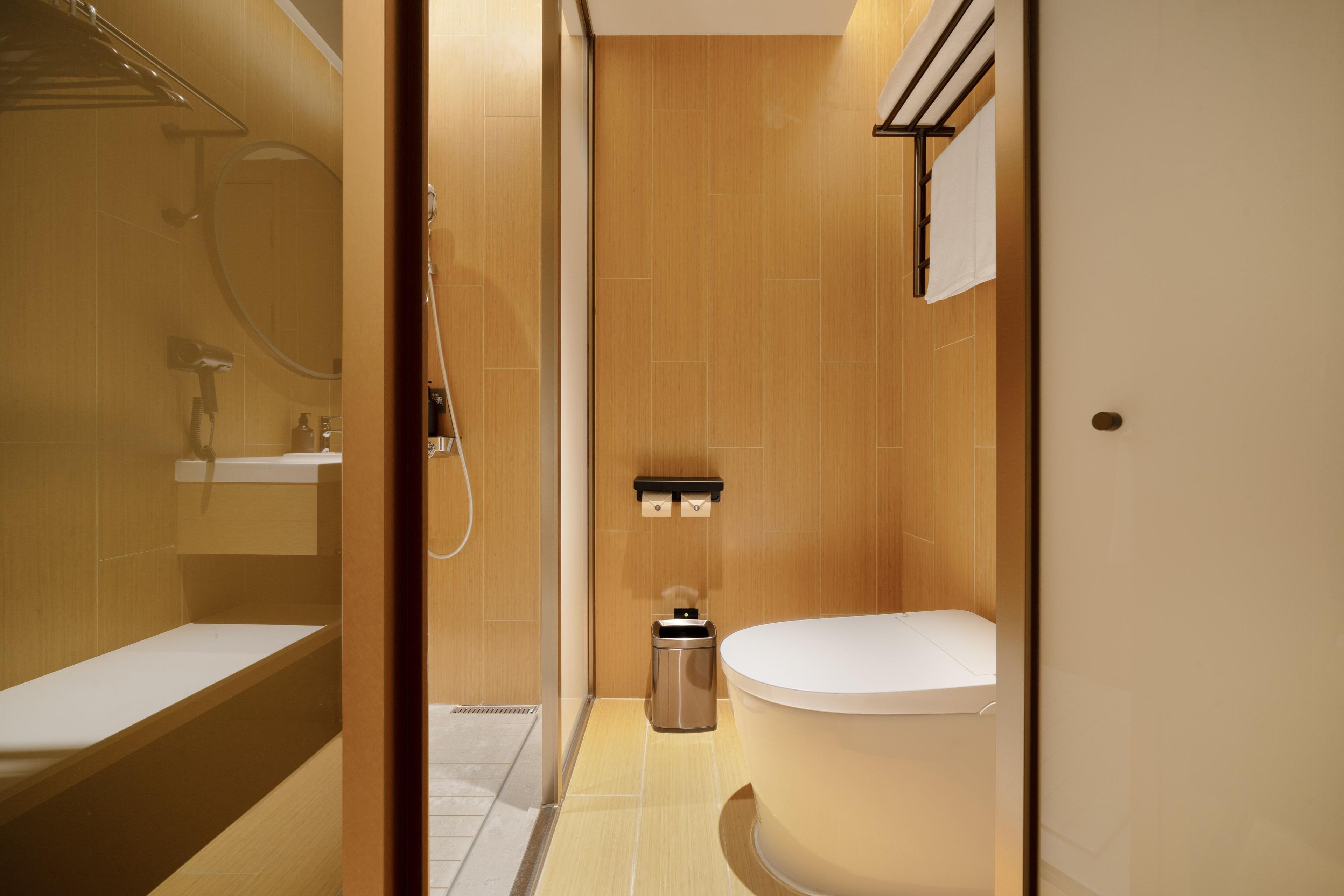 A modern bathroom with a bathtub, a toilet, and a shower area.