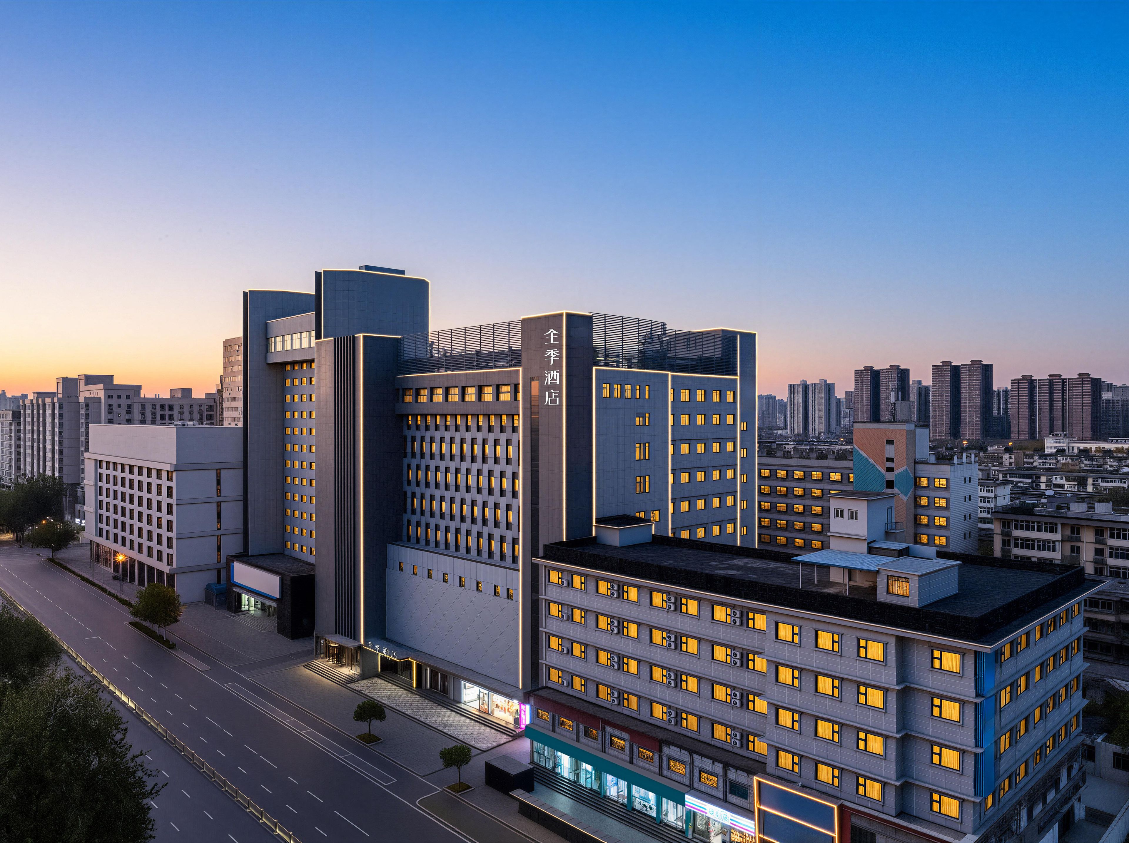 Un hotel moderno con varios pisos, una entrada destacada y vistas de la ciudad circundante.