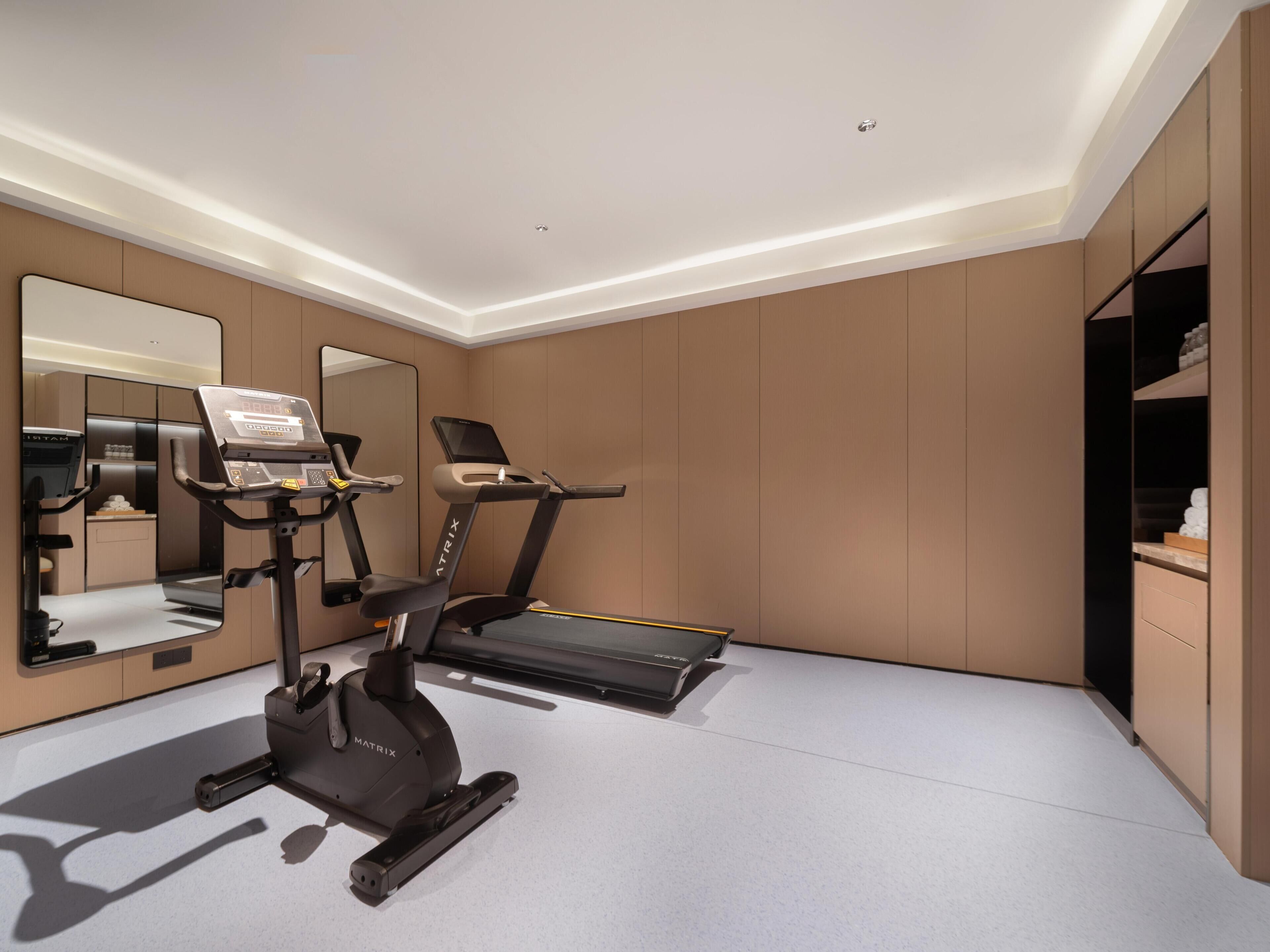 Una palestra domestica moderna con tapis roulant, una cyclette e un vogatore.