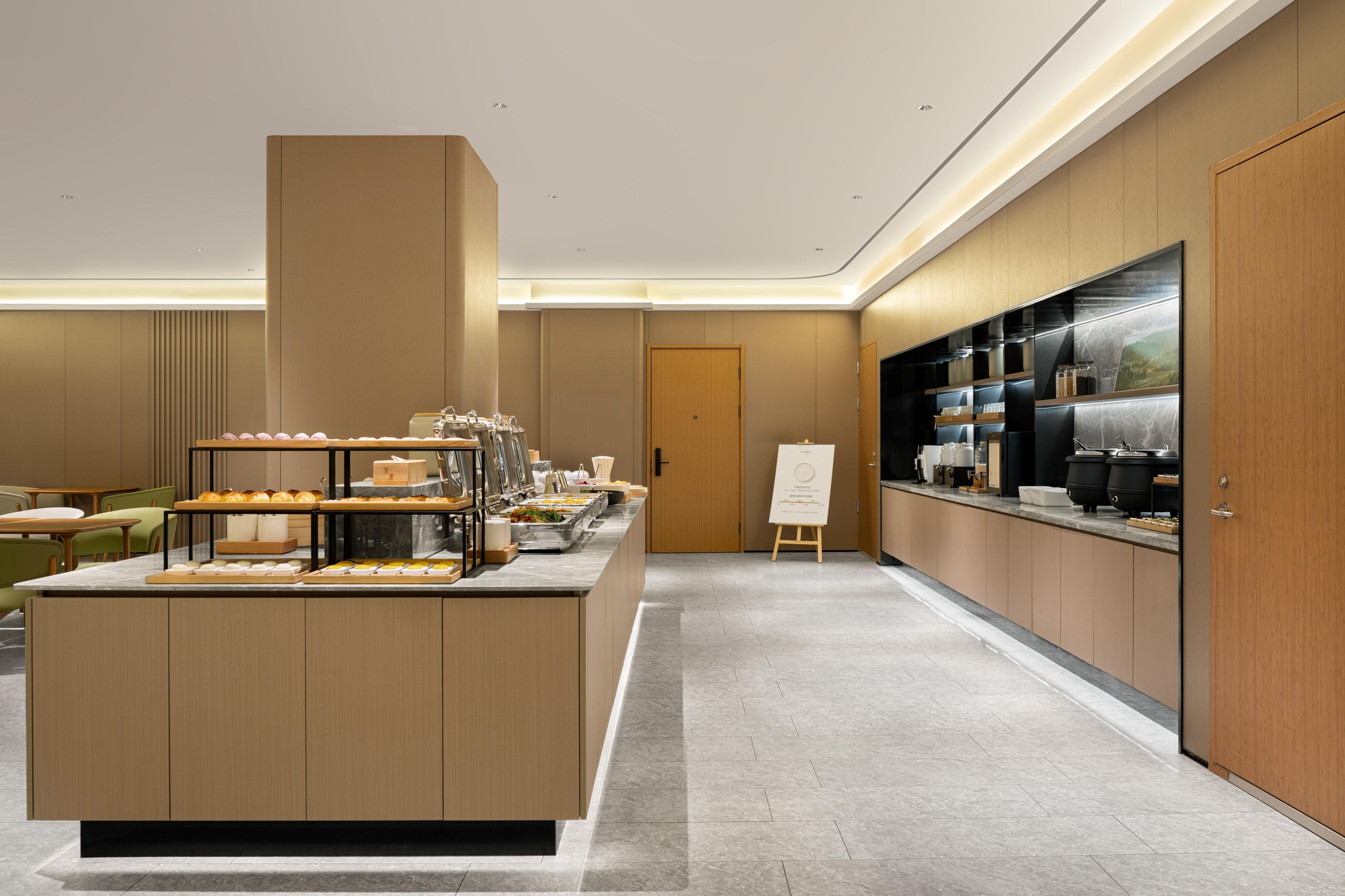 Un moderno comedor con servicio de buffet, una estación de café y vistas a la ciudad.